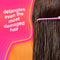 Person with long hair using a pink comb against a pink background with text "detangles even the most damaged hair".